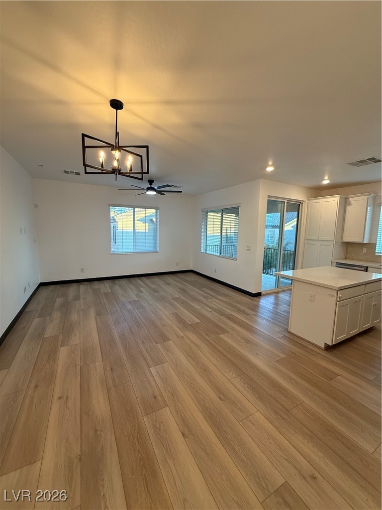 7368 North Decatur Boulevard, Unit 1 North Las Vegas, NV 89084 - Photo 4 of 17 Unfurnished dining area with light wood finished floors, ceiling fan, a chandelier, and recessed lighting