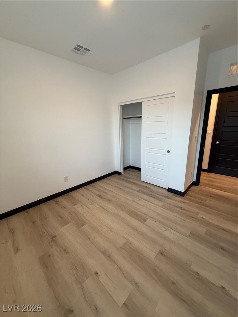 7368 North Decatur Boulevard, Unit 1 North Las Vegas, NV 89084 - Photo 7 of 17 Unfurnished bedroom with light wood-type flooring and a closet