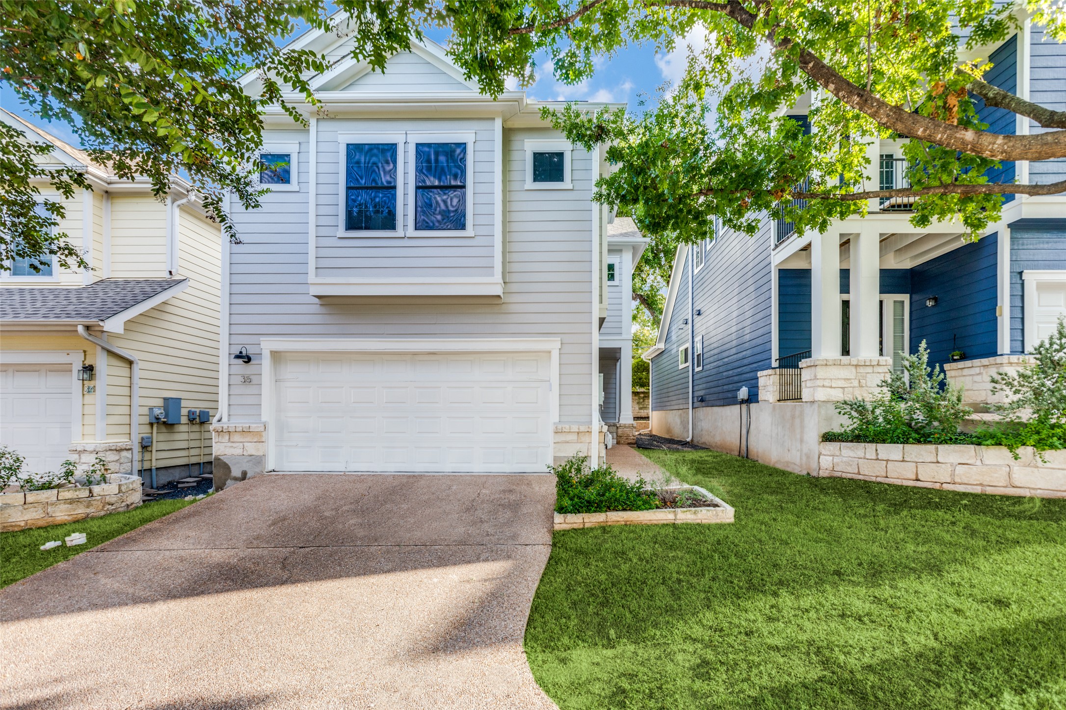 411 West St Elmo Road, Unit 35 Austin, TX 78745 - Photo 3 of 21 Traditional home featuring a garage, driveway, and a front lawn