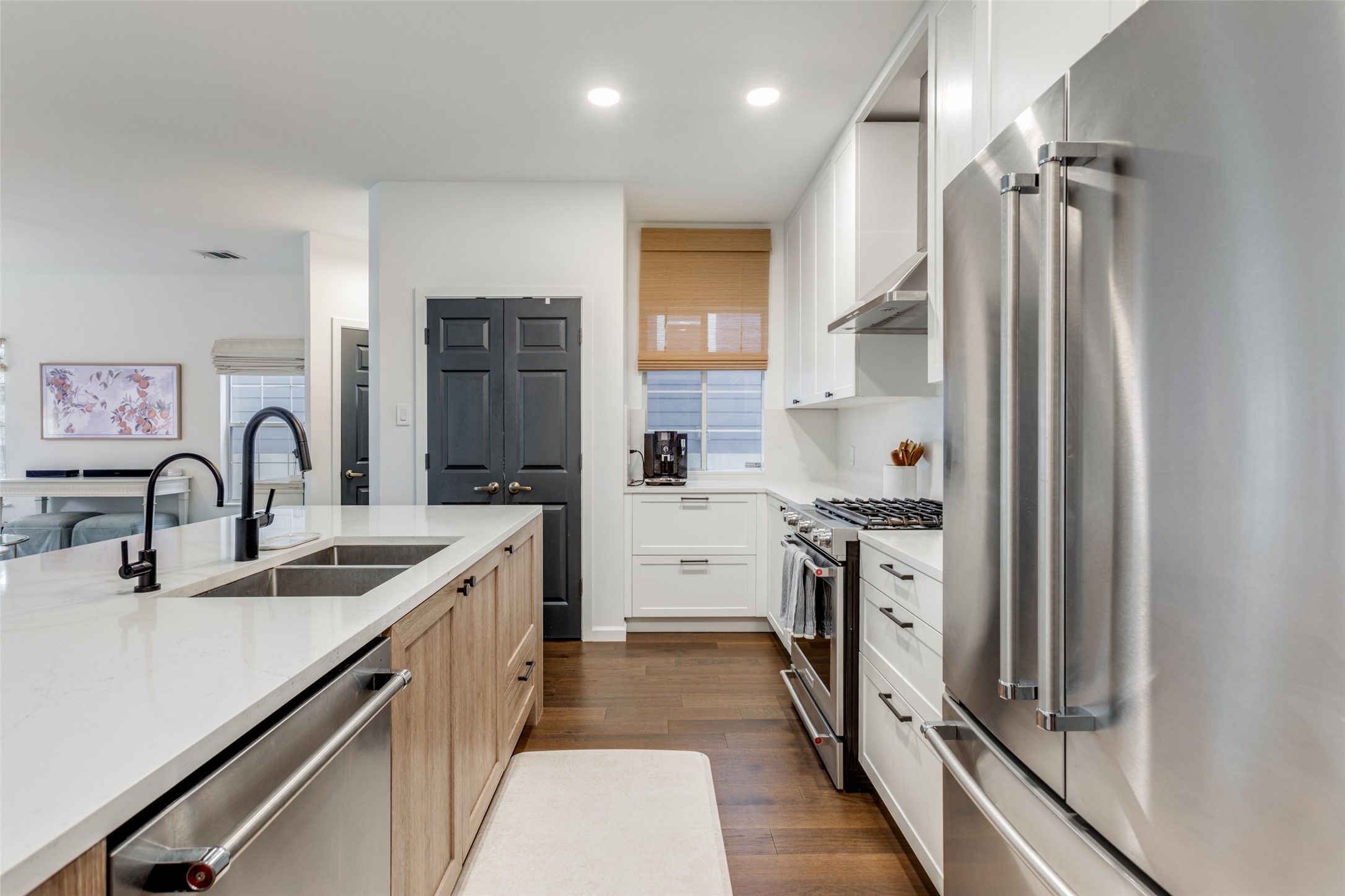 411 West St Elmo Road, Unit 35 Austin, TX 78745 - Photo 6 of 21 Dual tone kitchen with stainless steel appliances, two tone cabinetry, dark wood finished floors, light stone countertops, and recessed lighting