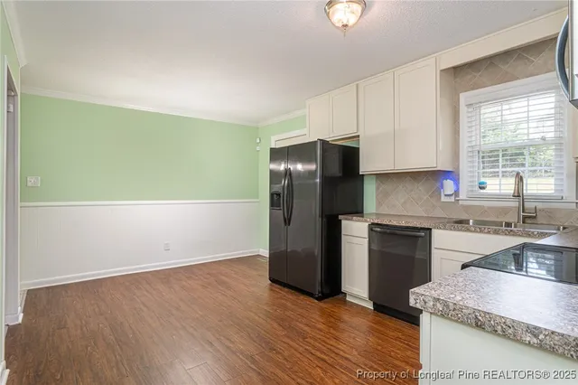 a kitchen with granite countertop a refrigerator stove and sink