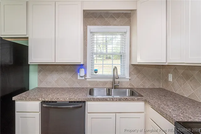 a kitchen with granite countertop stainless steel appliances white cabinets granite counter tops and a wooden floor
