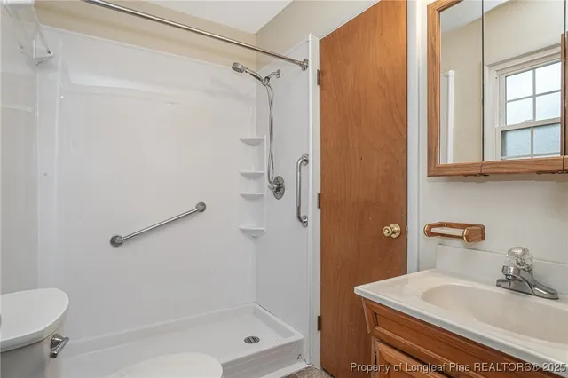 a bathroom with a sink a toilet and shower