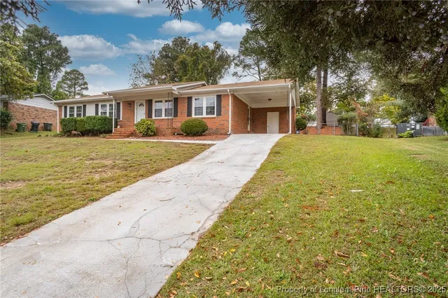 a front view of a house with a yard and lake view