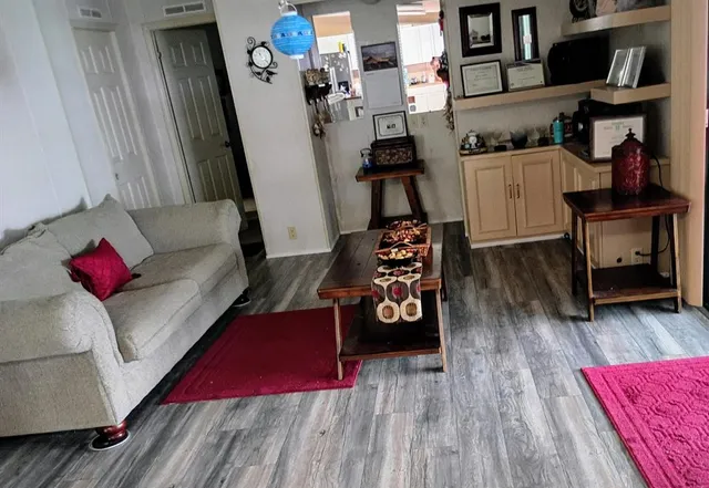 a living room with furniture and a wooden floor