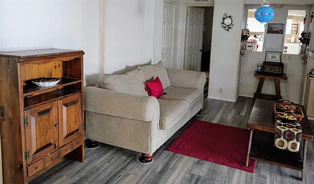 a living room with furniture and wooden floor