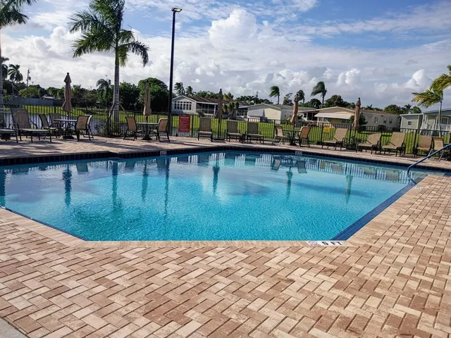 a view of swimming pool with outdoor seating and yard in the back