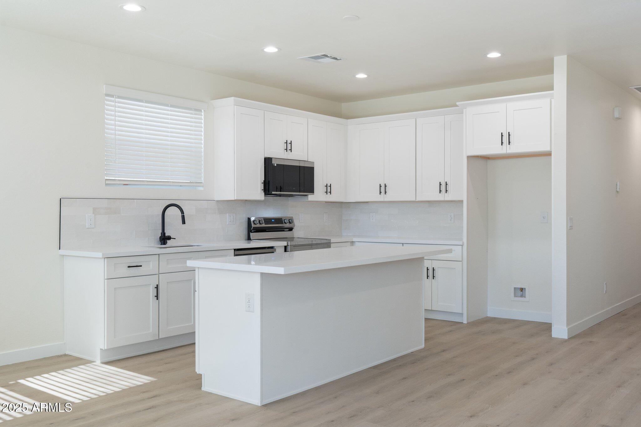 141 West Latona Road Phoenix, AZ 85041 - Photo 5 of 13 a kitchen with white cabinets stainless steel appliances and sink