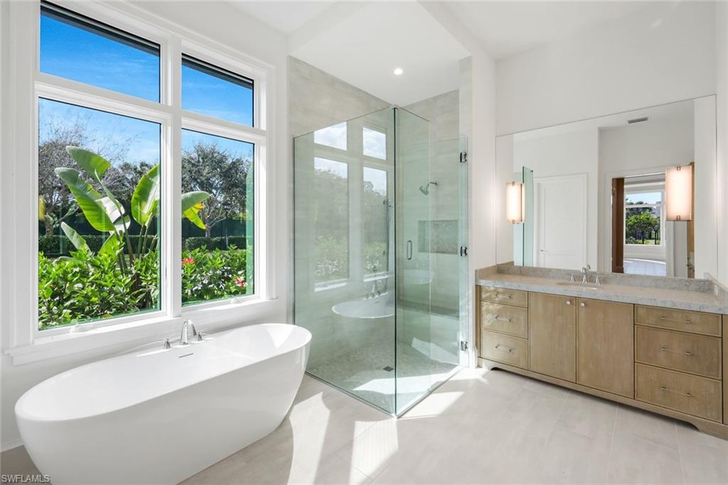 16728 Enclave Circle Naples, FL 34110 - Photo 23 of 49 Full bath with a freestanding tub, a shower stall, vanity, and light tile patterned floors