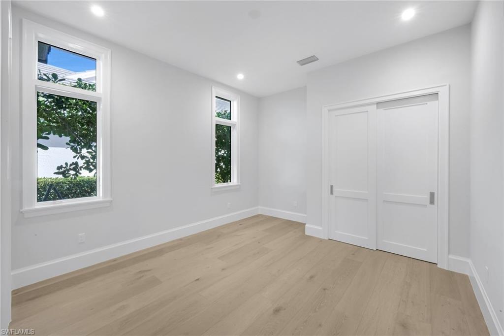 16728 Enclave Circle Naples, FL 34110 - Photo 34 of 49 Unfurnished bedroom featuring light wood-type flooring, recessed lighting, and a closet