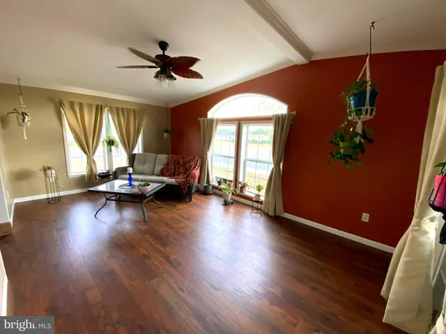 a view of a livingroom with hardwood floor and a ceiling fan