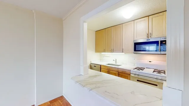 a kitchen with stainless steel appliances granite countertop a sink and a stove top oven