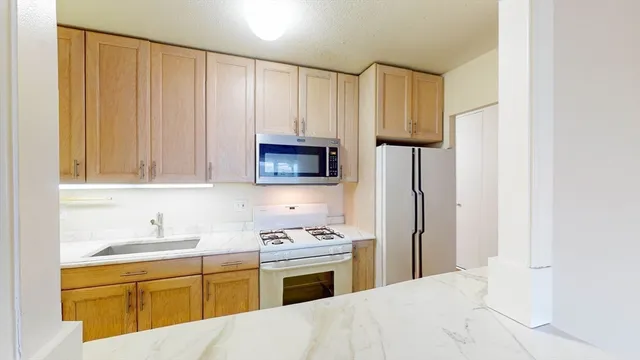 a kitchen with granite countertop a sink stainless steel appliances and cabinets