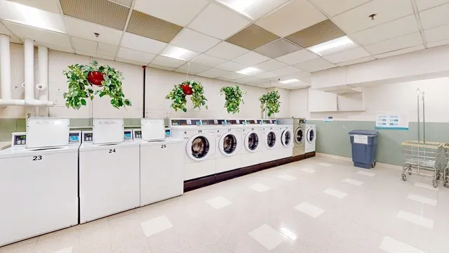 a white kitchen with stainless steel appliances a white stove top oven a sink and a refrigerator