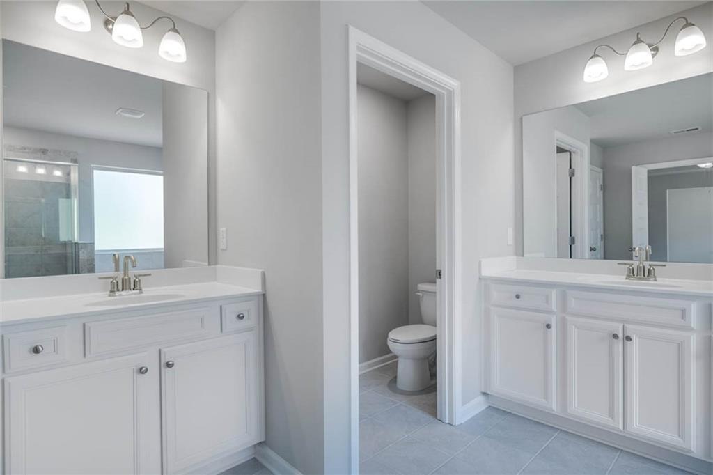 113 Canal Street Hampton, GA 30228 - Photo 19 of 33 a bathroom with a toilet sink and mirror