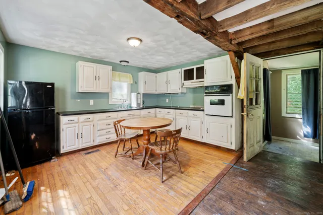 a kitchen with stainless steel appliances kitchen island granite countertop a sink cabinets and wooden floor