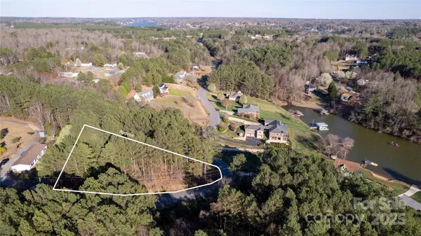 an aerial view of a house with a yard and lake view