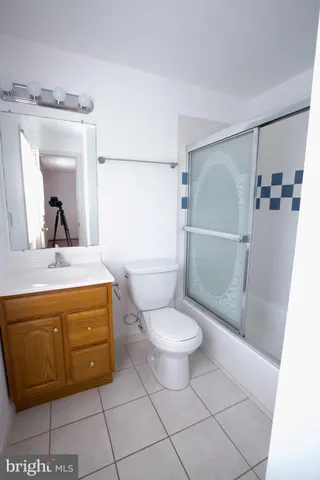 a bathroom with a granite countertop sink a toilet and a mirror