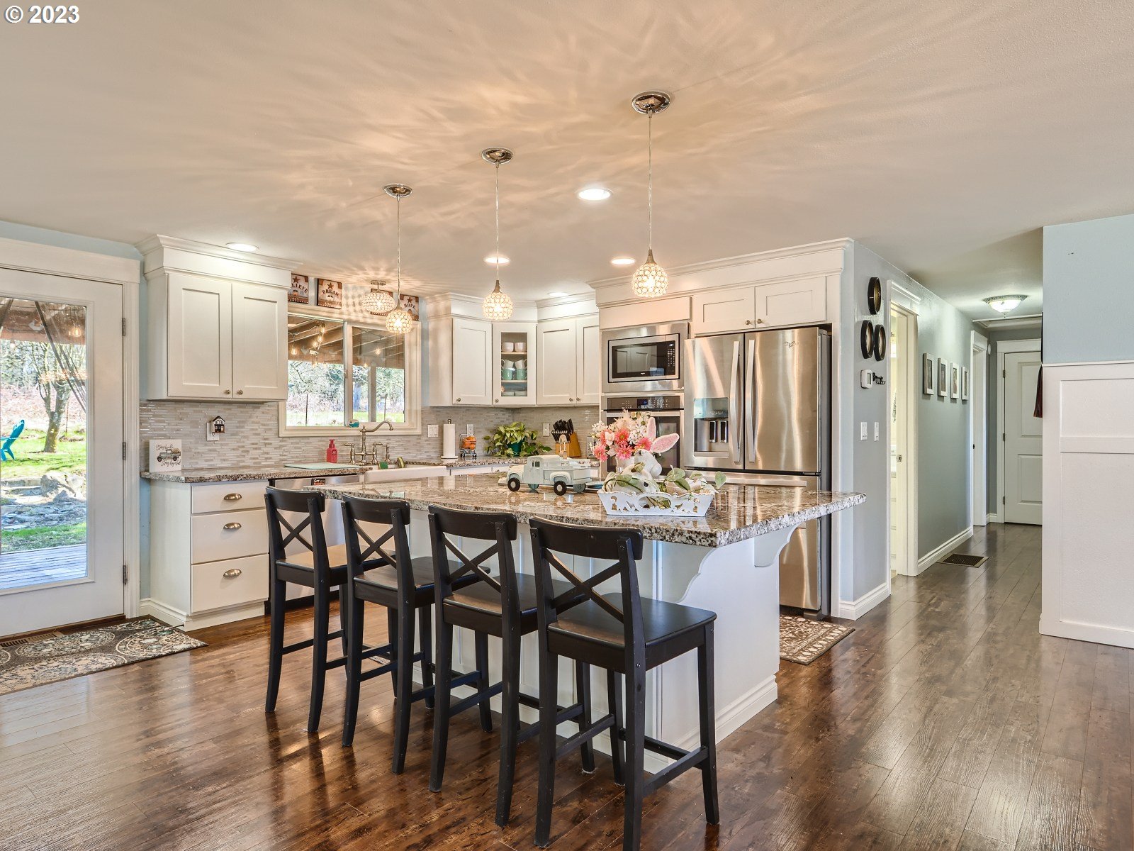 1830 Southeast Christensen Road Corbett, OR 97019 - Photo 5 of 28 a kitchen with stainless steel appliances a dining table chairs and wooden floor