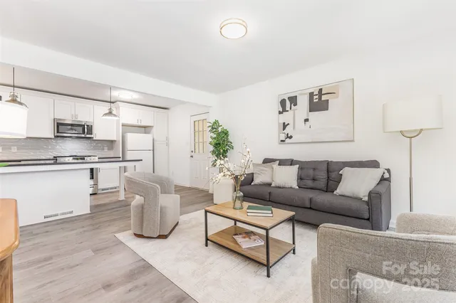 a living room with furniture and kitchen view