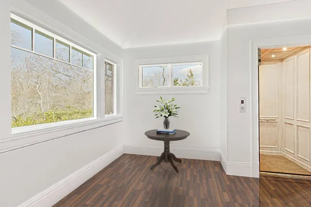 a view of a hallway with wooden floor and a window