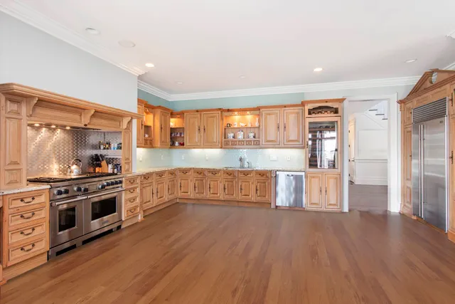 a kitchen with stainless steel appliances a stove top oven and a refrigerator