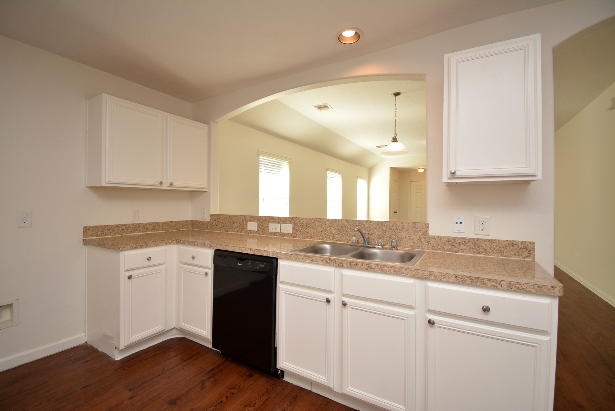 12010 Gregory Crossing Way Houston, TX 77067 - Photo 11 of 26 a kitchen with a sink dishwasher and white cabinets with wooden floor