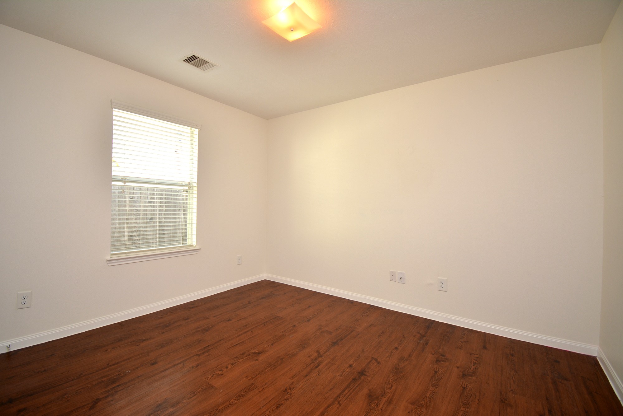12010 Gregory Crossing Way Houston, TX 77067 - Photo 17 of 26 an empty room with wooden floor and windows