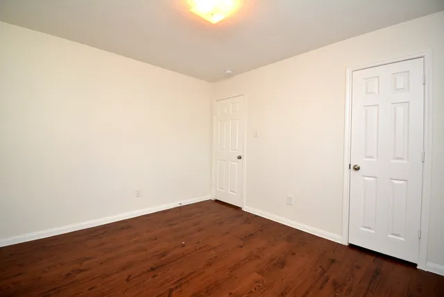 a view of an empty room with wooden floor