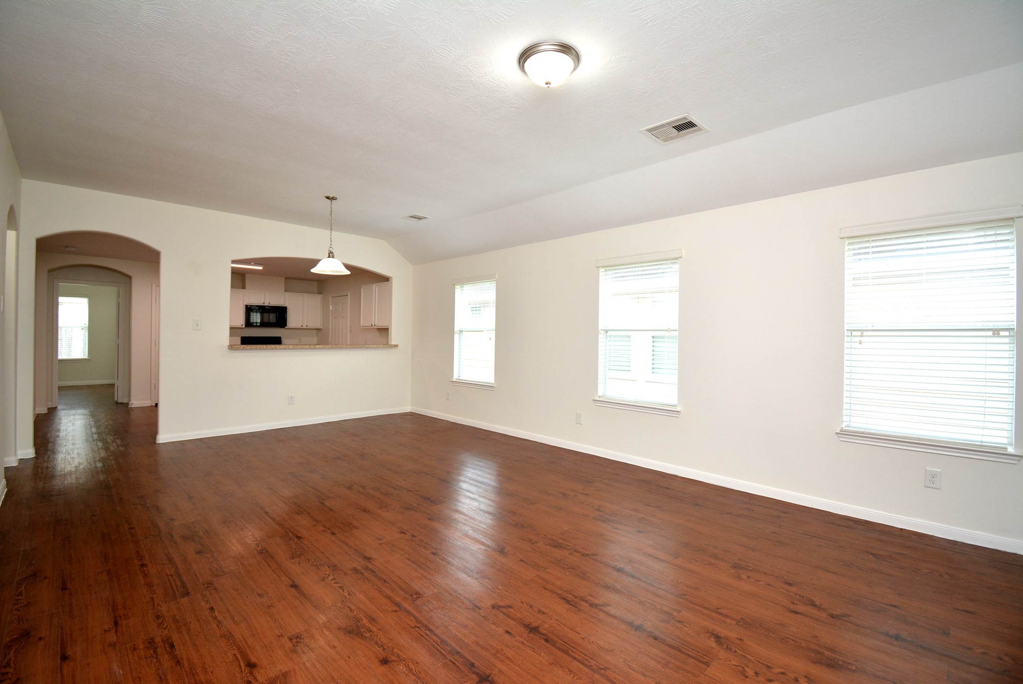 12010 Gregory Crossing Way Houston, TX 77067 - Photo 5 of 26 an empty room with wooden floor and windows