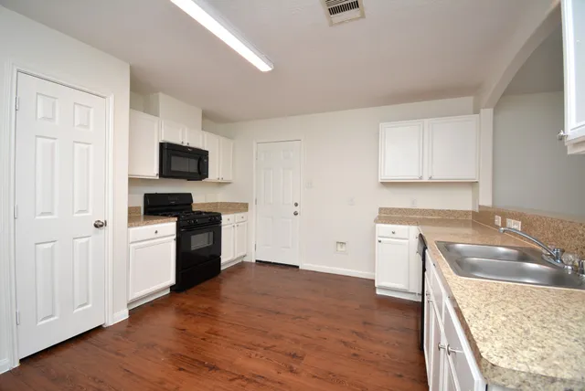 a kitchen with a stove a sink and a microwave