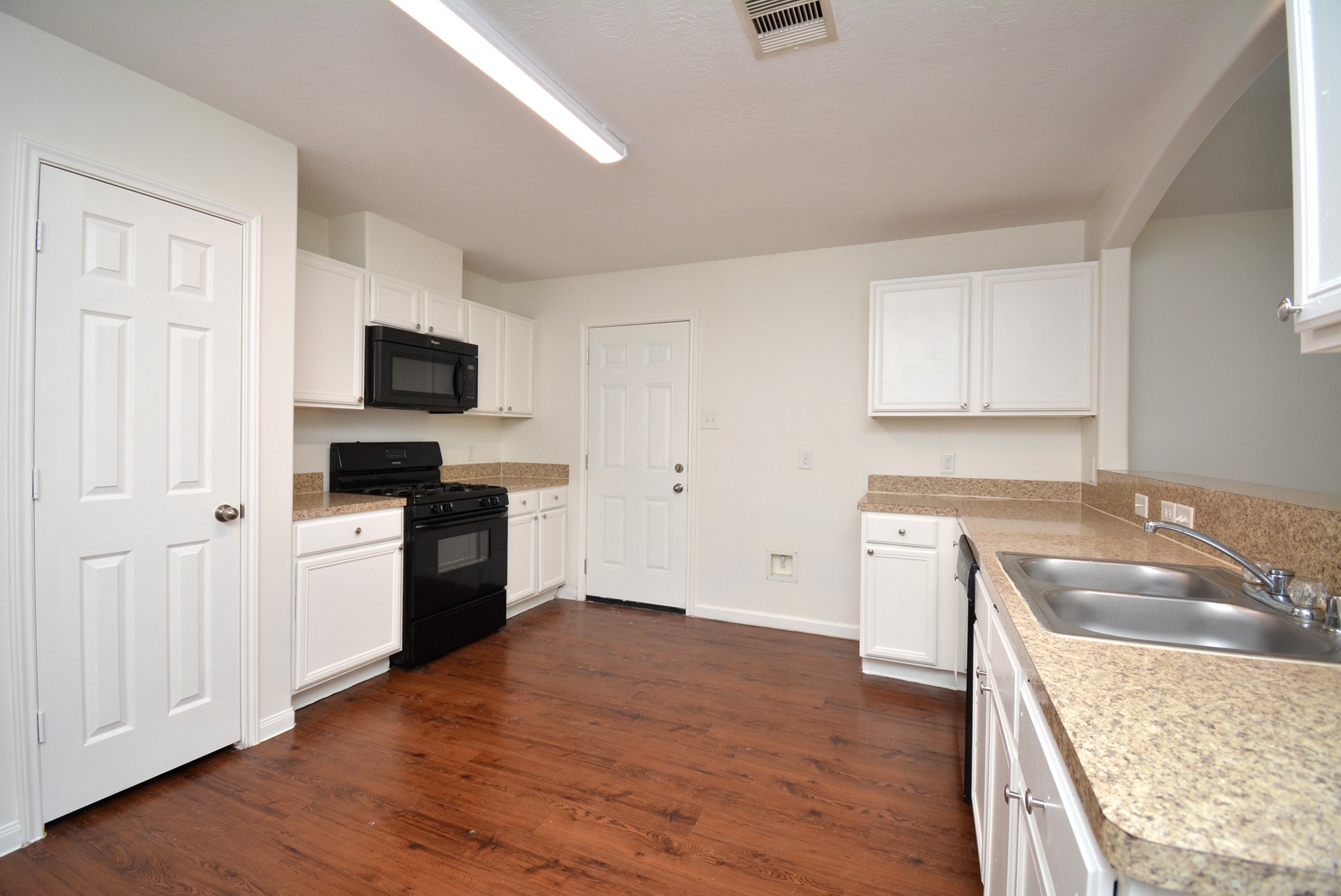 12010 Gregory Crossing Way Houston, TX 77067 - Photo 8 of 26 a kitchen with a stove a sink and a microwave