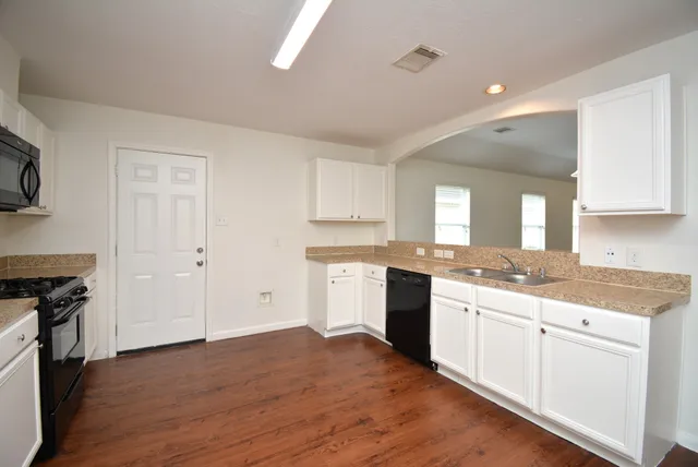 a kitchen with a sink stove and cabinets