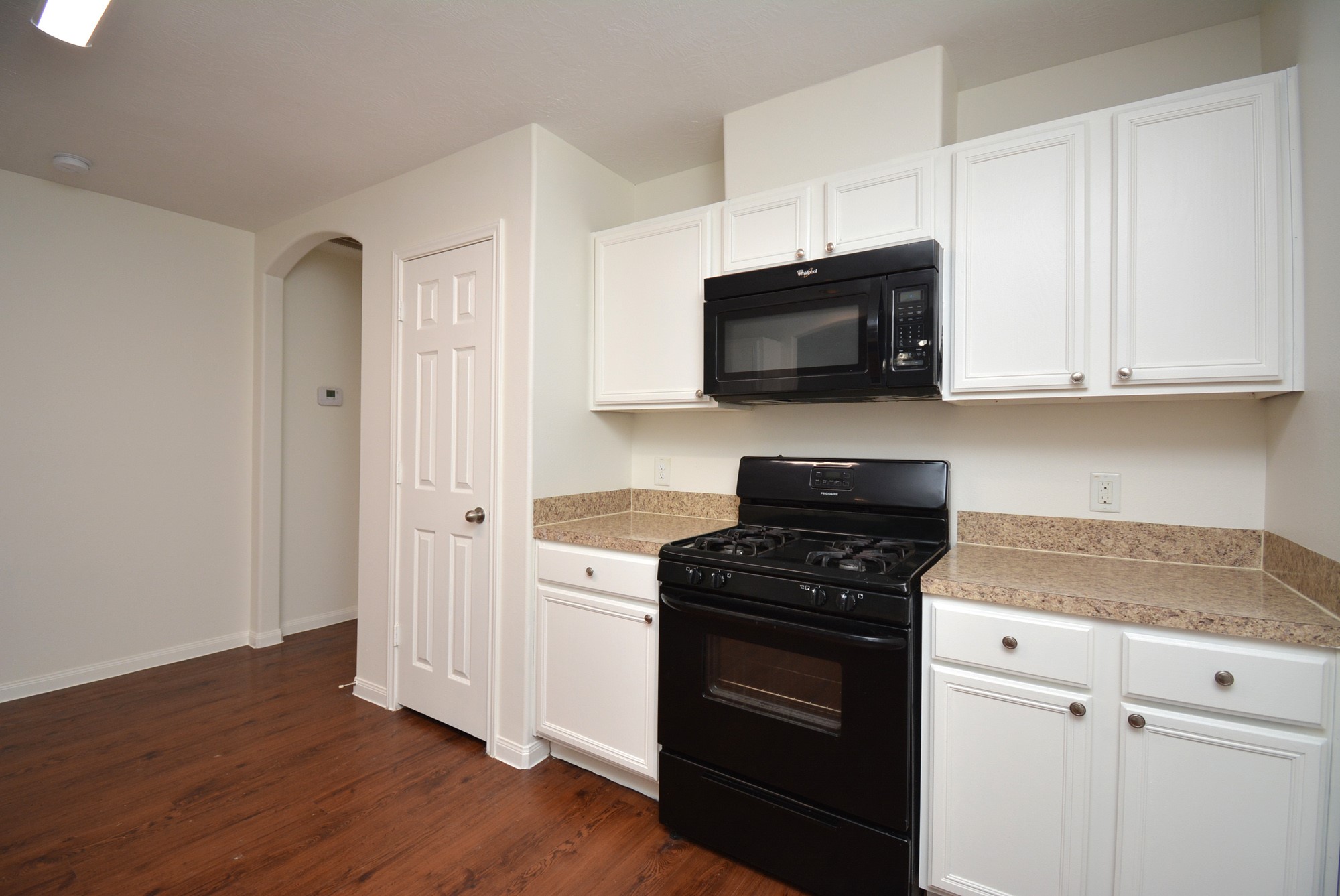 12010 Gregory Crossing Way Houston, TX 77067 - Photo 10 of 26 a kitchen with stainless steel appliances white cabinets and a stove top oven
