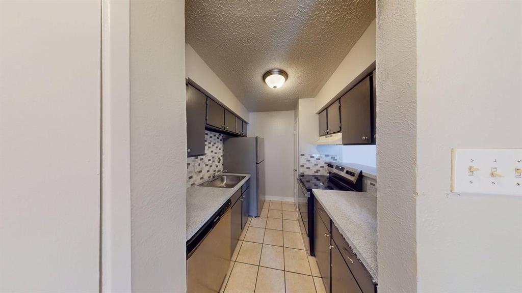 8110 Skillman Street, Unit 1046 Dallas, TX 75231 - Photo 2 of 10 a hallway with a refrigerator and cabinets