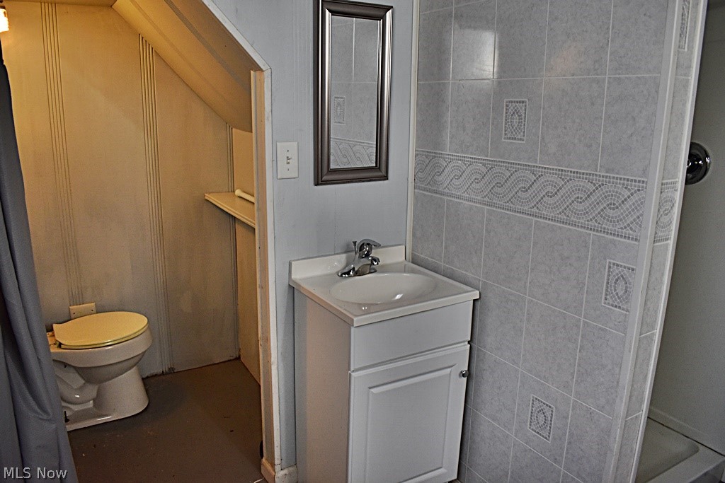 7715 Ackley Road Parma, OH 44129 - Photo 21 of 27 Bathroom featuring tile walls, toilet, and vanity