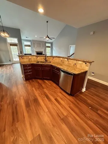 a kitchen with stainless steel appliances wooden cabinets a stove a sink a refrigerator and a microwave