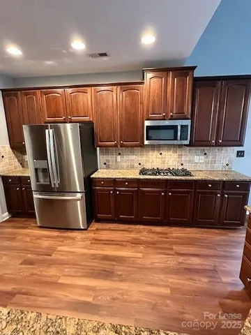 a kitchen with granite countertop a stove and a refrigerator