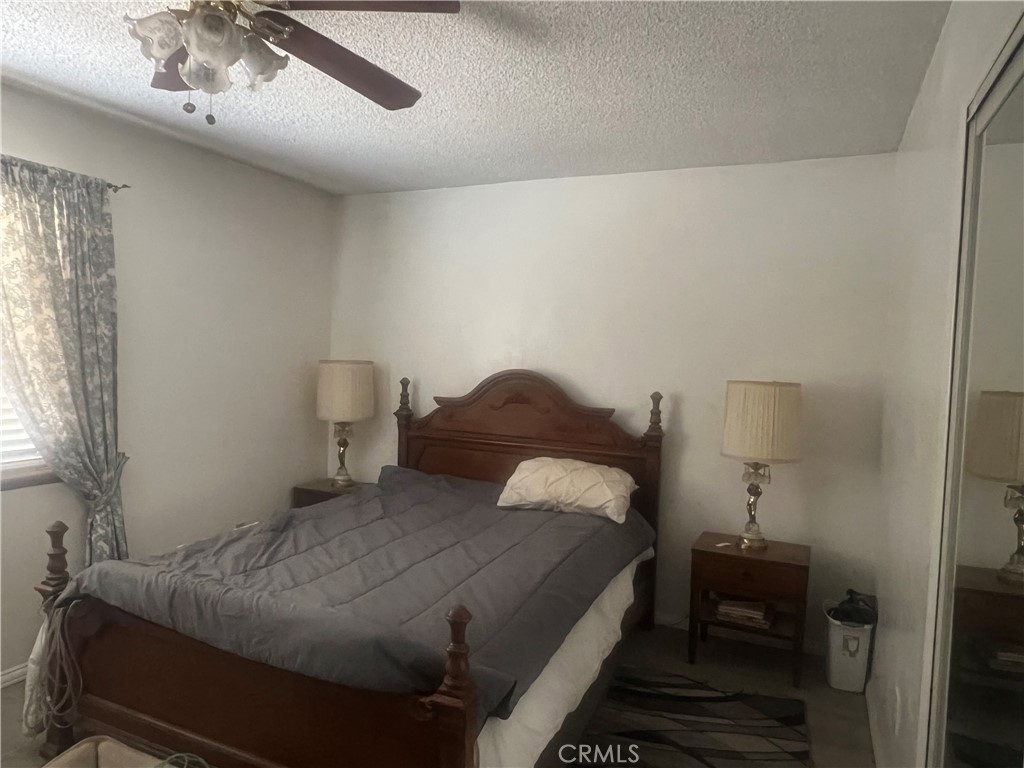 15411 Ash Street Hesperia, CA 92345 - Photo 11 of 11 a bedroom with a bed and a lamp