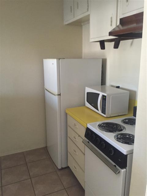 630 Maiden Lane, Unit H Austin, TX 78705 - Photo 2 of 8 Kitchen featuring white appliances, light countertops, and light tile patterned floors