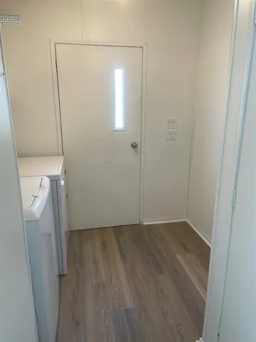 a view of a room with wooden floor and mirror