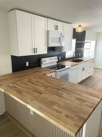 a kitchen with granite countertop a sink a stove and cabinets