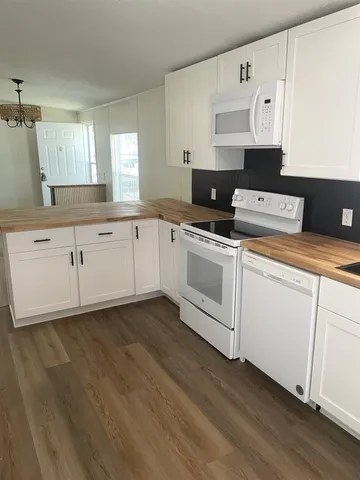 a kitchen with cabinets appliances and wooden floor