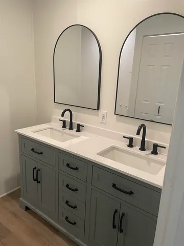 a bathroom with a double vanity sink and a mirror