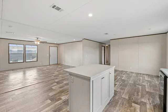 a view of an empty room with window and cabinet