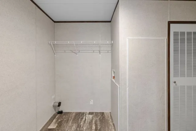 a view of walk in closet with empty racks