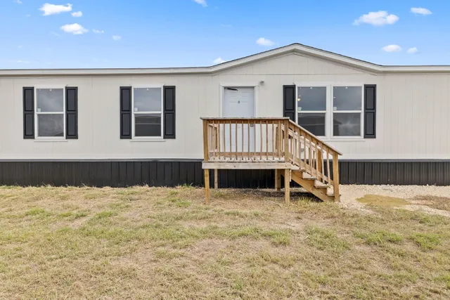 a view of an house with backyard and deck