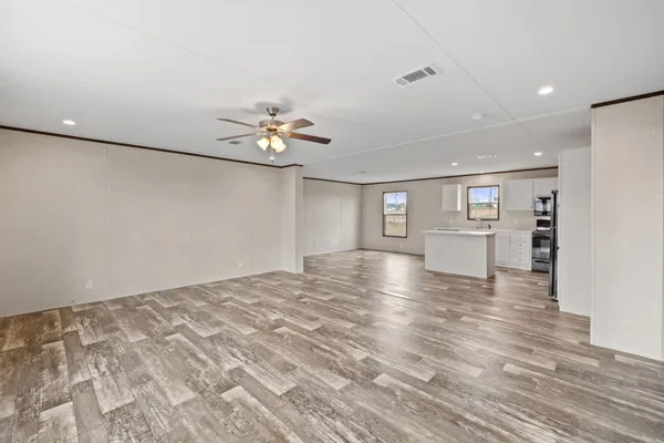 a view of an empty room with window and a ceiling fan