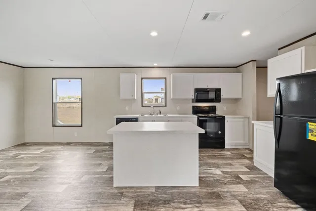 a living room with stainless steel appliances furniture a refrigerator and a kitchen counter top