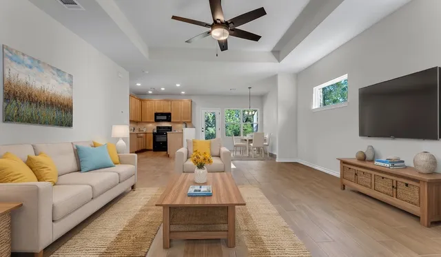 an empty room with a chandelier fan and windows